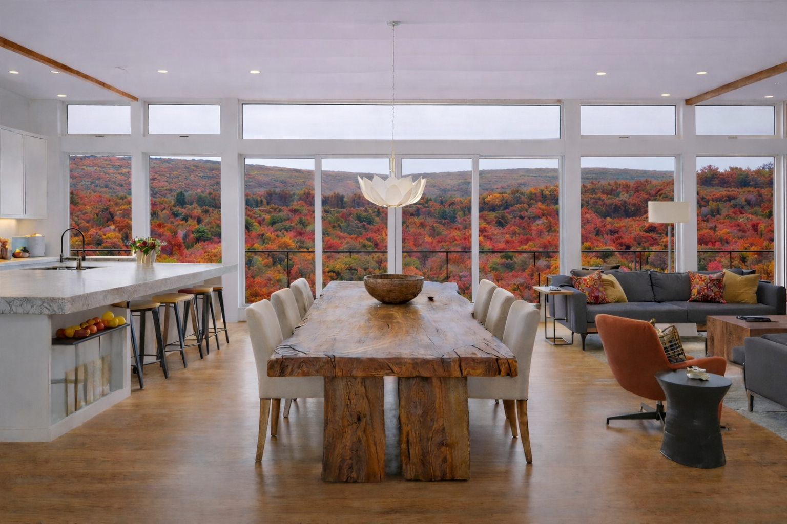 Open-plan living and dining room with panoramic windows overlooking fall foliage at a Graystones Preserve homesite