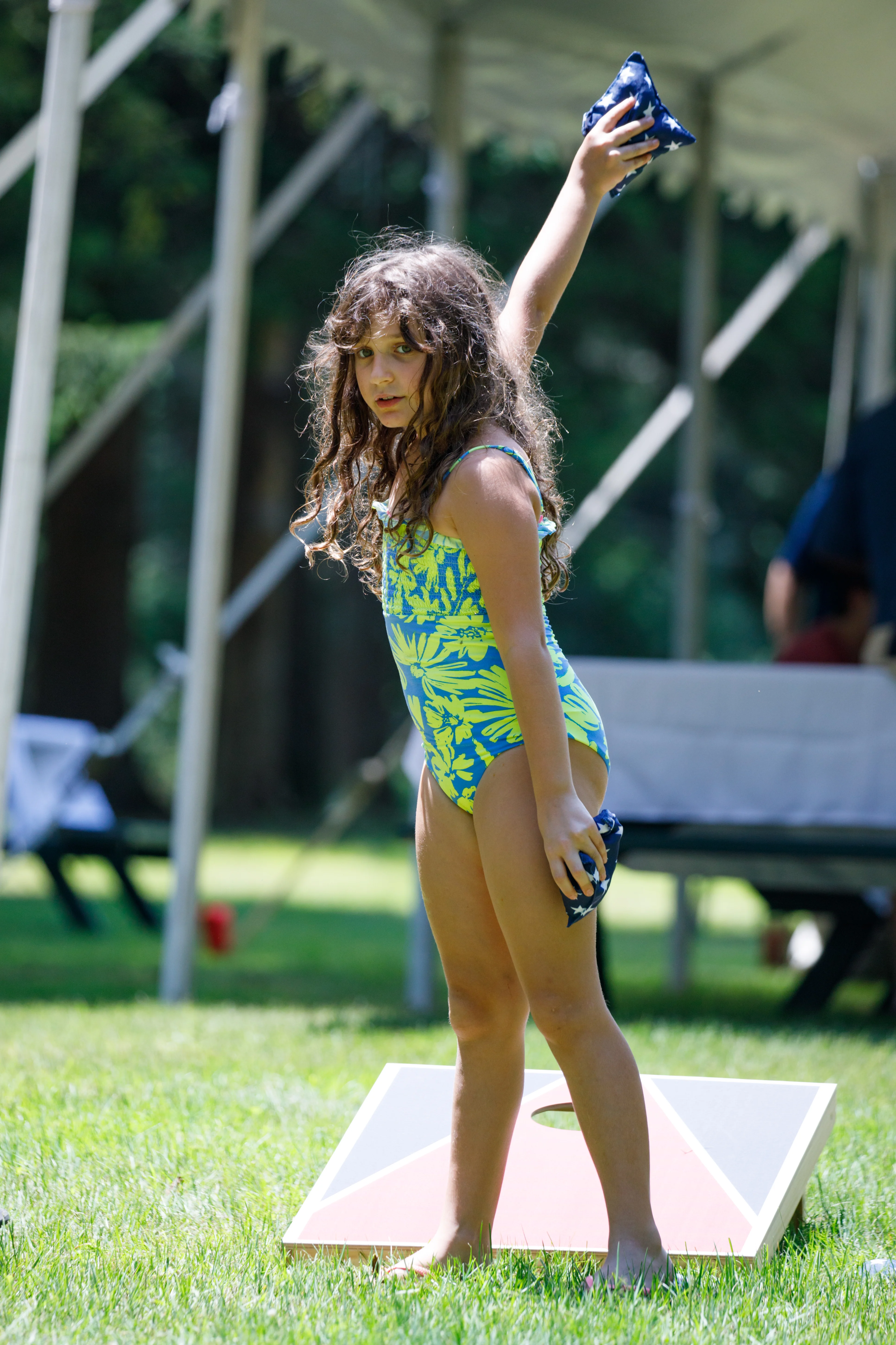Young girl playing cornhole in the sunshine